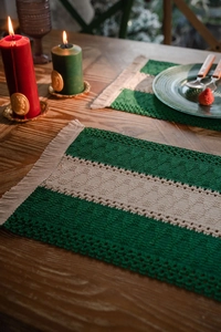 Macro detail of forest green and beige woven cotton placemat with elegant side tassels
