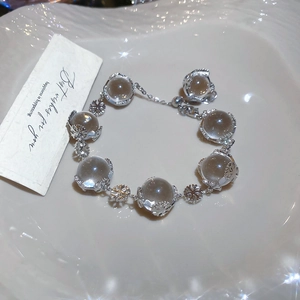 Detailed view of beaded snowflake bracelet with clear crystals on a textured white plate