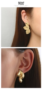Detailed view of 18K gold plated irregular geometric earrings worn by a model