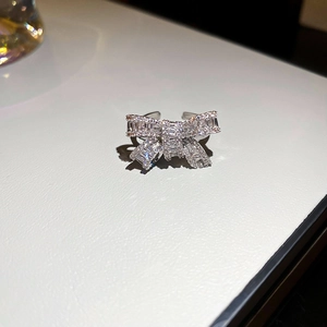 Detail shot of sparkling bow-shaped silver ring with micro-paved white zircons