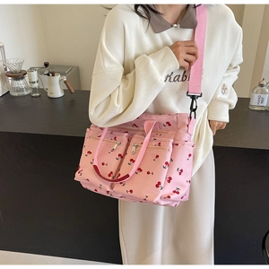 Detail view of pink canvas tote bag with cherry print and detachable shoulder strap