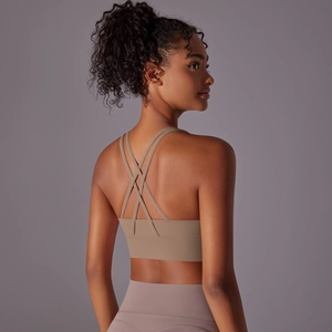 Dettaglio delle spalline incrociate sul reggiseno sportivo color nudo per yoga e fitness