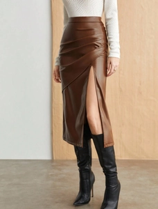 Detail view of brown faux leather midi skirt featuring waist pleats and a high side slit