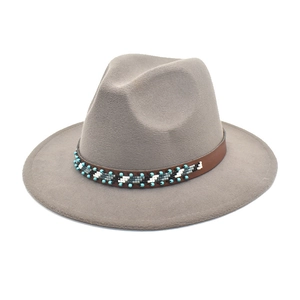 Détail du chapeau fedora gris en laine avec sangle en cuir et perles ethniques