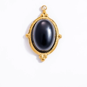 Detailed view of vintage 18k gold pendant with oval black obsidian gemstone and beaded frame