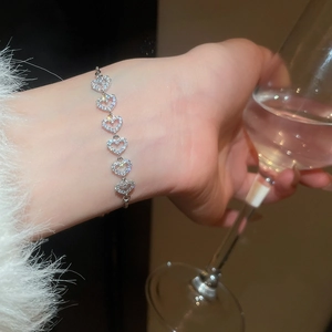 Détail du bracelet à maillons cœur avec zircons étincelants sur un poignet élégant