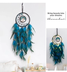 Detail of tree of life dreamcatcher with teal feathers and glowing LED light decoration