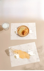 Disposable child placemat featuring cartoon cats, showing water absorption and food-grade material