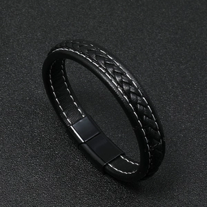 Detail of black woven leather bracelet with white stitching and magnetic metal clasp
