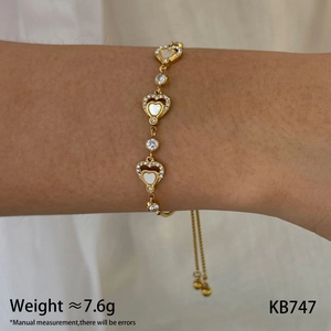 Detail of adjustable gold heart bracelet with shell inlay and cubic zirconia on wrist