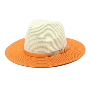 Detail of two-tone Panama straw hat with cream top, orange brim and gold buckle strap