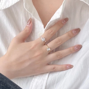 Close-up of elegant gold and silver rings with rectangular zircon on model finger