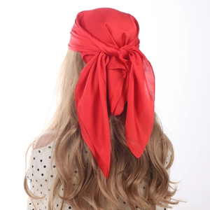 Detailed back view of a bright red satin square scarf tied as a stylish headpiece