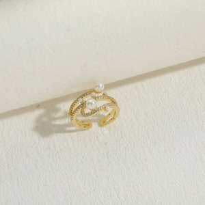 Close-up of gold layered ring with five white pearls and shimmering zircon pavé stones