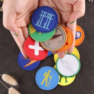 Handheld group of colorful round embroidered scout badges with high-density stitching details