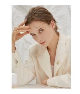 Detailed view of an elegant flower brooch with opal pearls on a beige blazer lapel