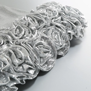 Detailed view of silver sequin fabric with 3D rose flower design and metallic luster