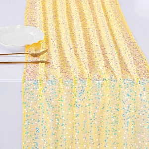 Golden mermaid sequin table runner with iridescent shimmer on white fabric backdrop