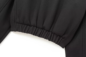 Detail of elastic ribbed cuffs on a black cropped bomber jacket with woven texture