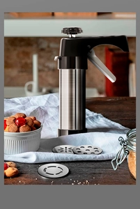 Detail of stainless steel cookie press gun with various metal pattern discs for baking