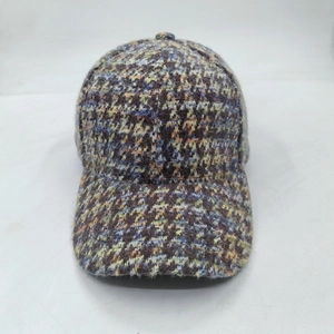 Close-up of textured checkered tweed baseball cap with ear protection for winter