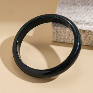 Detail of dark green acrylic bangle featuring vintage marble texture on a display box
