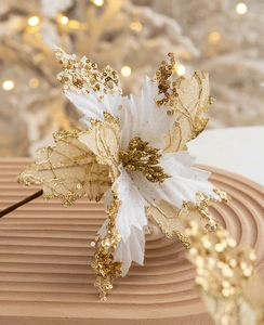 Detail of 20cm gold sequined Christmas flower on a rustic wooden tray with bokeh lights