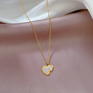 Close-up of gold titanium steel necklace featuring a heart-shaped pave-set pendant on silk