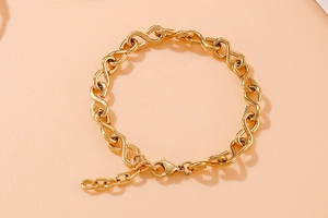 Detailed macro view of the gold infinity link bracelet with adjustable lobster clasp