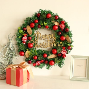 Festlicher grüner Weihnachtskranz mit roten Kugeln, Zuckerstangen und Merry Christmas Logo