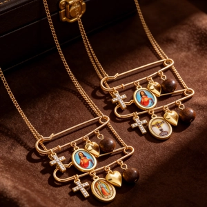 Close-up of vintage gold paperclip necklaces with cross, heart and religious medals
