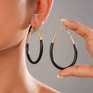 Minimalist gold and black enamel drop earrings shown on a model with elegant metallic finish