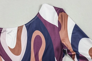 Macro shot of abstract geometric print fabric with purple and brown wavy patterns