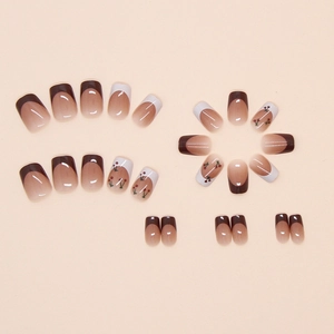 Detail of French minimalist press-on nails with deep brown tips and cherry patterns