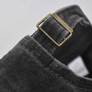 Detail of vintage bronze metal buckle and washed denim texture on adjustable baseball cap