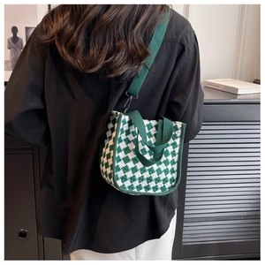 Detail of green checkerboard knit tote bag with adjustable shoulder strap and canvas handles