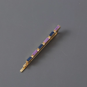Minimalist gold hair clip set with rectangle blue and purple rhinestones on grey background