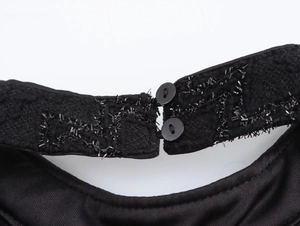 Detail of elegant black satin evening dress showing double-button collar with sequins