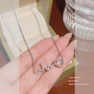 Macro view of silver lightning EKG heart pendant necklace with shimmering zircon stones