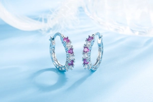 Macro shot of the S925 sterling silver hallmark and pink crystals on silver hoop earrings