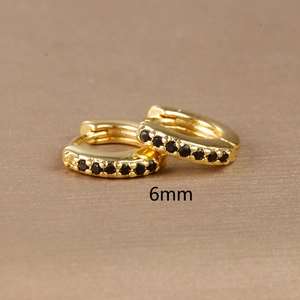 Minimalist 6mm gold hoop earrings with black zircon stones shown in a macro detail shot