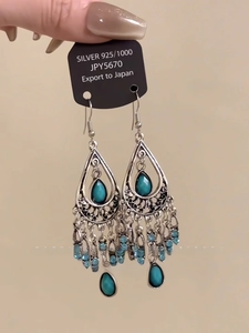 Detailed view of silver 925 bohemian drop earrings with blue beads and flowing tassels