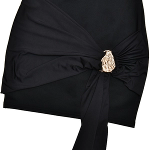 Close-up of black dress waist featuring golden decorative buckle and pleated design details