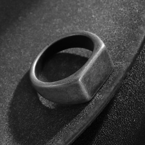 Macro detail of men's square signet ring featuring a brushed vintage oxidized finish