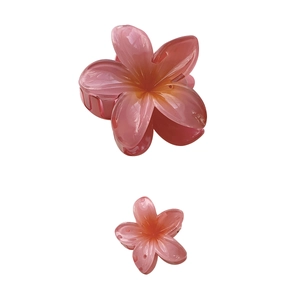 Gradient plumeria flower hair claws in pink and orange resin for vacation hairstyles