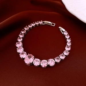 Detail of tennis bracelet featuring pink zircon stones on deep red velvet background