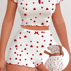 Detail of white rib-knit pajamas with red heart print and ruffled lettuce edge trim