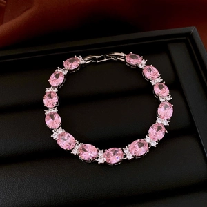 Détails d'un bracelet de luxe avec zircons roses ovales dans un coffret cadeau avec soie