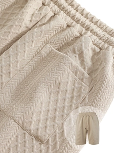 Detailed close-up of beige waffle knit fabric and drawstring waistband on casual shorts