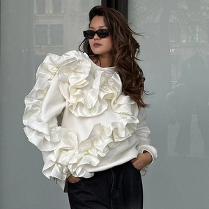 Détail d'un élégant sweat-shirt blanc à volants avec manches longues texture soyeuse